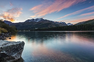 Pink sky at dawn illuminates the peaks reflected in Lake Sils, Engadine Pink sky at dawn illuminates the peaks reflected in Lake Sils, Engadine