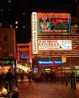 Sign Collection: The Raymond Revuebar with neon signs in red light area at night, Soho, London