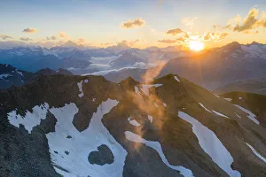 Last rays of sunset light the rocky mountain peaks, Furka Pass, Canton Uri, Switzerland Last rays of sunset light the rocky mountain peaks, Furka Pass, Canton Uri, Switzerland