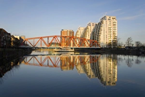 Residential tower blocks and colourful bridge reflected in water, Salford Quays, Salford Residential tower blocks and colourful bridge reflected in water, Salford Quays, Salford