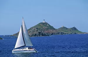 Sailing boat with the Semaphore Lighthouse behind, Iles Sanguinaires, island of Corsica