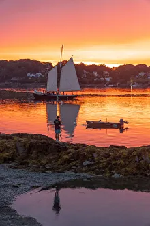 A schooner returns to dock at sunset at Bailey Island, Casco Bay, Maine A schooner returns to dock at sunset at Bailey Island, Casco Bay, Maine