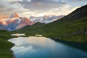 Schreckhorn and Finsteraarhorn peaks reflected in Bachalpsee lake at sunset, Grindelwald Schreckhorn and Finsteraarhorn peaks reflected in Bachalpsee lake at sunset, Grindelwald