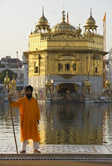 Shrine guard in orange clothes holding lance standing Shrine guard in orange clothes holding lance standing