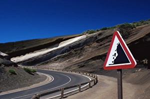 Sign on road with stratified volcanic rocks in the background, Parque Nacional del Teide Sign on road with stratified volcanic rocks in the background, Parque Nacional del Teide