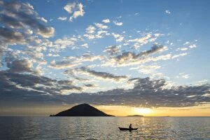 Silhouette of a man in a little fishing boat at sunset, Cape Malcear, Lake Malawi