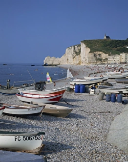 Small boats and people on the beach with cliffs in the background, at Etretat Small boats and people on the beach with cliffs in the background, at Etretat