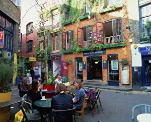 Small group of people sitting outdoors at tables of a cafe in Neals Yard Small group of people sitting outdoors at tables of a cafe in Neals Yard