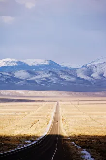 Snow capped mountains on a straight road of American south west, U Snow capped mountains on a straight road of American south west, U