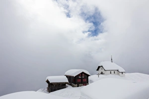 Snow covered mountain huts and church surrounded by low clouds, Bettmeralp Snow covered mountain huts and church surrounded by low clouds, Bettmeralp