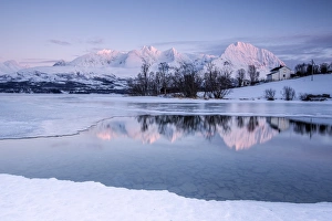 Snowy peaks are reflected in the frozen Lake Jaegervatnet at sunset, Stortind, Lyngen Alps Snowy peaks are reflected in the frozen Lake Jaegervatnet at sunset, Stortind, Lyngen Alps