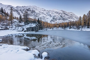 The snowy peaks are reflected in the frozen Lake Mufule, Malenco Valley, Province of Sondrio