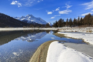 Snowy peaks are reflected in Lake Silvaplana still partially frozen, Maloja, Canton of Graubunden Snowy peaks are reflected in Lake Silvaplana still partially frozen, Maloja, Canton of Graubunden