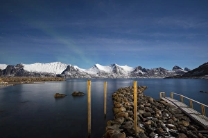 Stars of the polar night frame the frozen sea surrounded by snowy peaks, Mefjord Berg Stars of the polar night frame the frozen sea surrounded by snowy peaks, Mefjord Berg