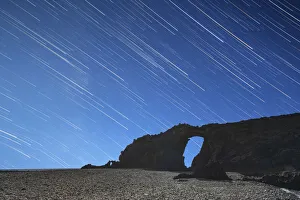 Startrail over the natural stone arch Arco del Jurado at Pena Horadada beach Startrail over the natural stone arch Arco del Jurado at Pena Horadada beach