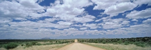 Straight gravel road cutting across grassy plain near Windhoek Straight gravel road cutting across grassy plain near Windhoek
