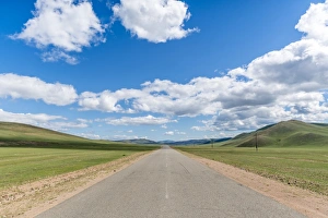 Straight road in the Mongolian steppe and clouds in the sky, North Hangay province Straight road in the Mongolian steppe and clouds in the sky, North Hangay province
