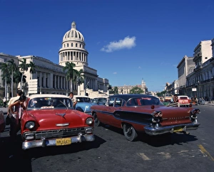 Street scene of old American automobiles used as taxis parked near the Capitolio Building Street scene of old American automobiles used as taxis parked near the Capitolio Building