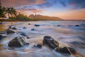 Sunrise over the calm bay waters at Anahola Beach Park, Kalalea mountain in the distance Sunrise over the calm bay waters at Anahola Beach Park, Kalalea mountain in the distance