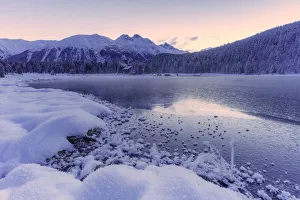 Sunrise over the frozen lake Lej da Staz and snowy woods, St Sunrise over the frozen lake Lej da Staz and snowy woods, St
