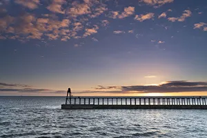Sunrise over the North Sea and Whitby harbour and piers in late summer, Whitby Sunrise over the North Sea and Whitby harbour and piers in late summer, Whitby