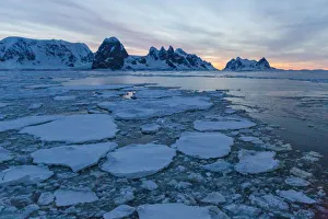 Sunrise on snow-covered mountains and dense sea ice in Neumayer Channel Sunrise on snow-covered mountains and dense sea ice in Neumayer Channel