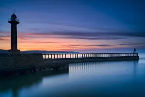 Sunset afterglow over Whitby West Pier and lighthouse, the North Yorkshire coast Sunset afterglow over Whitby West Pier and lighthouse, the North Yorkshire coast