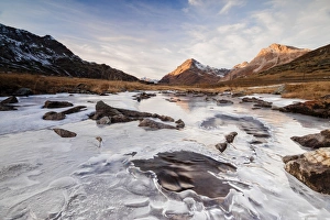 Sunset frames the alpine creek covered with ice at Bernina Pass, Canton of Graubunden Sunset frames the alpine creek covered with ice at Bernina Pass, Canton of Graubunden