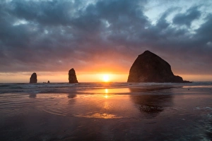 Sunset behind Haystack Rock at Cannon Beach on the Pacific Northwest coast, Oregon Sunset behind Haystack Rock at Cannon Beach on the Pacific Northwest coast, Oregon