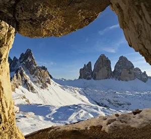Sunset over the snow capped Tre Cime di Lavaredo and Monte Paterno seen from rock cave Sunset over the snow capped Tre Cime di Lavaredo and Monte Paterno seen from rock cave