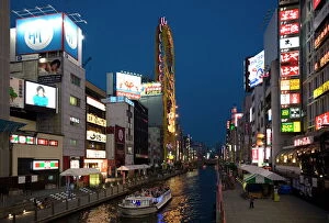 Images Dated 9th May 2009: Tour boat on Dotonbori River glides past shops and restaurants in Namba