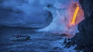 A tour boat observes lava pouring into the sea from 60 feet above as steam plumes billow A tour boat observes lava pouring into the sea from 60 feet above as steam plumes billow