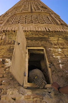 Tourist climbing into the minaret by a window, 12th Century Minaret of Jam Tourist climbing into the minaret by a window, 12th Century Minaret of Jam