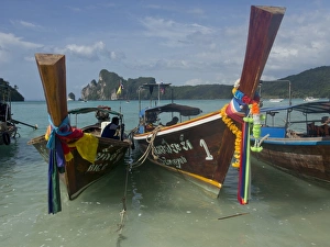 Tourists on long-tail boat in the Phi Phi islands, Andaman Sea, Thailand, Southeast Asia Tourists on long-tail boat in the Phi Phi islands, Andaman Sea, Thailand, Southeast Asia