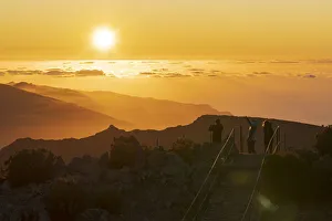 Tourists photographing sunset with smartphone from Pico Ruivo mountain peak, Madeira Tourists photographing sunset with smartphone from Pico Ruivo mountain peak, Madeira