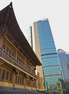 Traditional Chinese wooden architecture next to modern Chinese glass and steel buildings Traditional Chinese wooden architecture next to modern Chinese glass and steel buildings