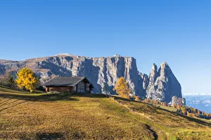 Traditional huts at Alpe di Siusi (Seiser Alm) in autumn with Sciliar peaks in background Traditional huts at Alpe di Siusi (Seiser Alm) in autumn with Sciliar peaks in background