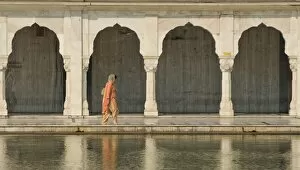 Images Dated 11th February 2008: Traditionally dressed woman walking along one of the pools at the Bangla Sahib Sikh Temple in Delhi