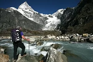 Images Dated 4th January 2000: A trekker pauses for a break on the edge of a glacial stream on the way to Mera Peak