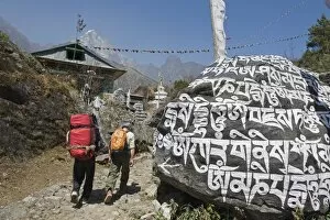 Backpackers Gallery: Trekkers walking past a mani stone, Solu Khumbu Everest Region, Sagarmatha National Park