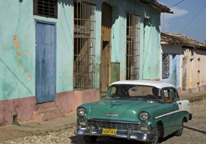 Typical paved street with colourful houses and old American car, Trinidad Typical paved street with colourful houses and old American car, Trinidad