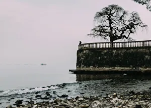 Unidentified woman looking at Lake Maggiore on a cold winters day, Piedmont, Italian Lakes Unidentified woman looking at Lake Maggiore on a cold winters day, Piedmont, Italian Lakes