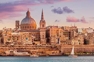 Valletta skyline at sunset with the Carmelite Church dome and St. Pauls Anglican Cathedral, Valletta, Malta