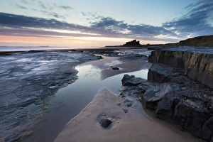 View towards Bamburgh Castle at sunrise from Bamburgh Beach, Bamburgh, Northumberland View towards Bamburgh Castle at sunrise from Bamburgh Beach, Bamburgh, Northumberland