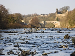 View along the boulder-strewn River Tees to the ruined castle and 16th century County Bridge View along the boulder-strewn River Tees to the ruined castle and 16th century County Bridge