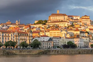 View from Mondego River to the old town with the university on top of the hill at sunset View from Mondego River to the old town with the university on top of the hill at sunset