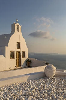 View of traditional white washed Church at sunset in Oia, Santorini, Greek Islands
