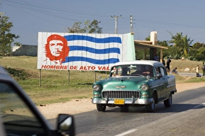 A vintage 1950s American Chevrolet on the road near Trinidad passing a colourful A vintage 1950s American Chevrolet on the road near Trinidad passing a colourful