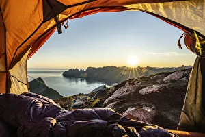 Warm lights of sunrise view from the inside of hiker's tent, Senja island Warm lights of sunrise view from the inside of hiker's tent, Senja island
