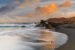 Waves crashing on sandy beach Playa de la Solapa at sunset, Fuerteventura, Canary Islands Waves crashing on sandy beach Playa de la Solapa at sunset, Fuerteventura, Canary Islands